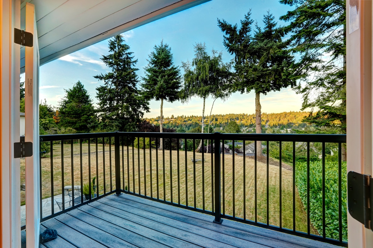 15:05 Garde-corps en aluminium noir sur balcon en bois avec vue sur terrain boisé résidentiel, Centre-du-Québec.